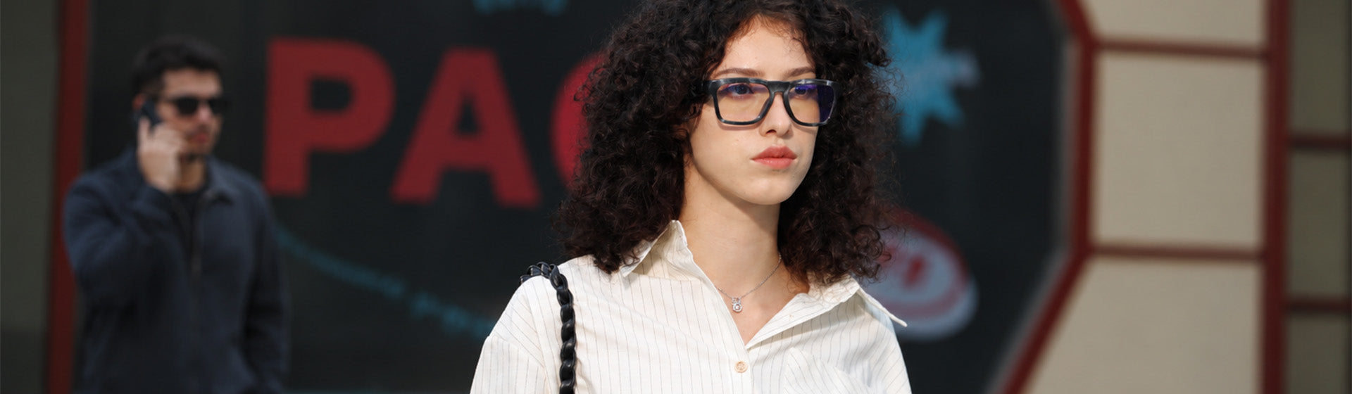 Woman on a city street at night wearing OhO Sunshine camera glasses for on-the-go recording