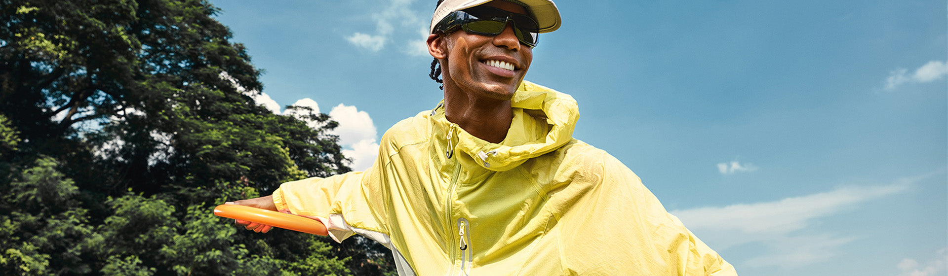 Person in a yellow jacket and cap playing outdoors in OhO Sunshine Focus camera sunglasses